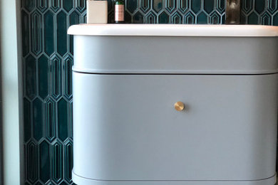 This is an example of a traditional half tiled bathroom in London with flat-panel cabinets, grey cabinets, a one-piece toilet, blue tiles, ceramic tiles, wood-effect flooring, a console sink, a single sink and a freestanding vanity unit.