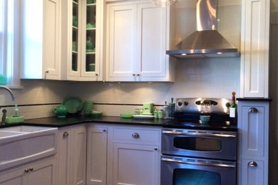 Inspiration for a mid-sized timeless l-shaped dark wood floor and brown floor enclosed kitchen remodel in Other with a farmhouse sink, shaker cabinets, white cabinets, soapstone countertops, white backsplash, subway tile backsplash, stainless steel appliances and no island