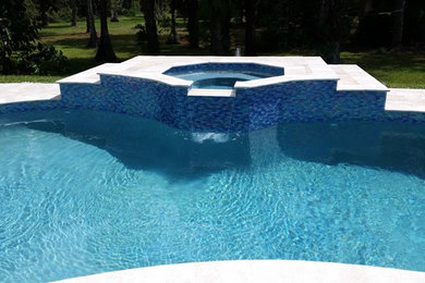 Example of a mid-sized trendy backyard stone pool fountain design in Miami
