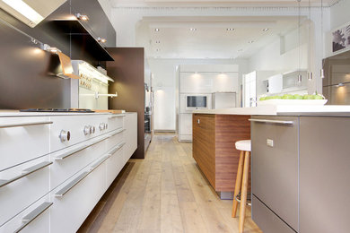 Contemporary kitchen in Edinburgh with flat-panel cabinets, white cabinets, panelled appliances and with island.