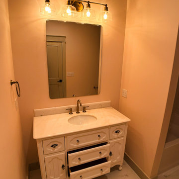 Elegant Guest Bath: Soft Terracotta Walls, Marble Vanity, and Modern Black Fixtu