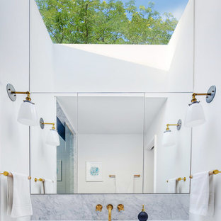 Immagine di una piccola stanza da bagno padronale minimalista con doccia alcova, WC sospeso, lastra di pietra, pareti bianche, pavimento in marmo, lavabo sottopiano, top in marmo, ante lisce e ante bianche