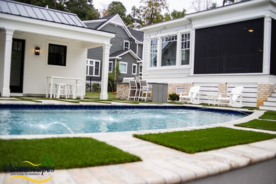 Diseño de piscina con fuente alargada moderna de tamaño medio a medida en patio trasero con suelo de baldosas