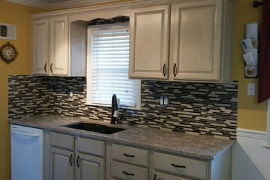 Example of a small trendy u-shaped enclosed kitchen design in Kansas City with an undermount sink, raised-panel cabinets, white cabinets, quartz countertops, gray backsplash, matchstick tile backsplash, white appliances and no island