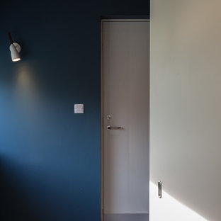 Medium sized modern study in Cambridgeshire with blue walls, ceramic flooring, a built-in desk and blue floors.