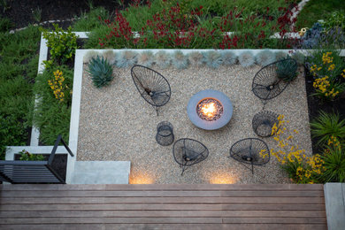 Photo of a mid-sized contemporary drought-tolerant and partial sun backyard gravel retaining wall landscape in San Francisco for summer.