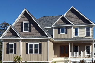 Example of a large transitional beige two-story vinyl gable roof design in Other
