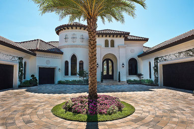 Double front door - huge mediterranean concrete floor double front door idea in Miami with white walls and a black front door