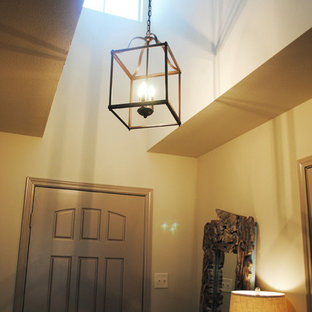 オースティンの中サイズの片開きドアエクレクティックスタイルのおしゃれな玄関ロビー (ベージュの壁、クッションフロア、グレーのドア) の写真