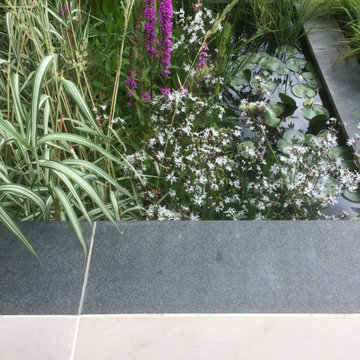 Natural Black Granite planks provide a frame for sandstone paving