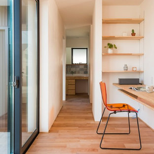 他の地域のモダンスタイルのおしゃれなホームオフィス・仕事部屋 (白い壁、無垢フローリング、造り付け机、茶色い床) の写真