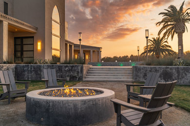 Minimalist courtyard gravel patio photo in Other with a fire pit
