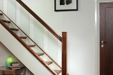 This is an example of a mid-sized modern wood straight staircase in London with wood risers.