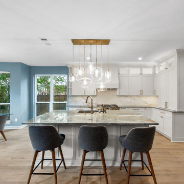 Symmetrical kitchen layout featuring an expansive island and a curved dining noo