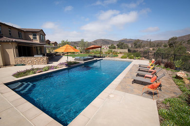 Example of a minimalist backyard stone and rectangular hot tub design in Phoenix