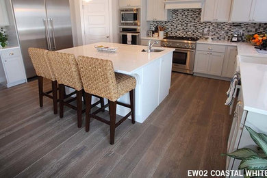 Inspiration for a medium sized contemporary l-shaped kitchen/diner in Houston with medium hardwood flooring, an island, a belfast sink, white cabinets, ceramic splashback, stainless steel appliances and brown floors.