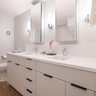 Esempio di una stanza da bagno moderna di medie dimensioni con ante lisce, ante bianche, pavimento in mattoni e top bianco