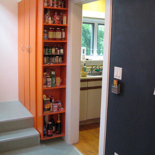 Idées déco pour une arrière-cuisine contemporaine de taille moyenne avec un placard sans porte, des portes de placard oranges et un sol gris.