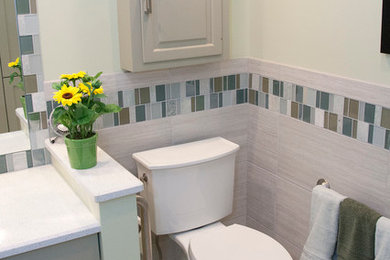 Inspiration for a mid-sized contemporary master white tile and glass tile ceramic tile bathroom remodel in Milwaukee with recessed-panel cabinets, green cabinets, a two-piece toilet, an undermount sink, quartzite countertops and green walls