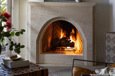 Example of a small eclectic limestone floor and gray floor living room design in San Diego with white walls, a corner fireplace, a stone fireplace and no tv