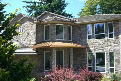 This is an example of a large traditional two-storey grey exterior in Portland with stone veneer.