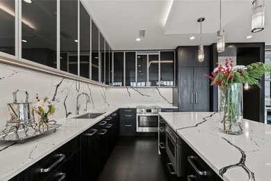 Eat-in kitchen - mid-sized modern l-shaped dark wood floor and black floor eat-in kitchen idea in Detroit with an undermount sink, flat-panel cabinets, black cabinets, quartz countertops, white backsplash, quartz backsplash, paneled appliances, an island and white countertops
