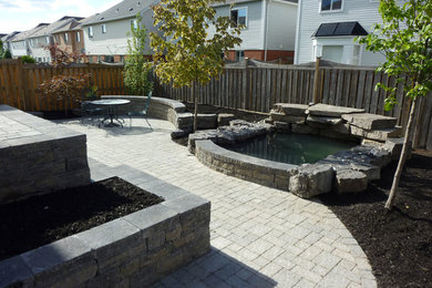 This is an example of a mid-sized backyard water fountain landscape in Toronto.