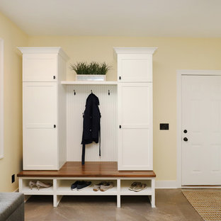 Design ideas for a medium sized classic galley utility room in Grand Rapids with shaker cabinets, white cabinets, laminate countertops, yellow walls, laminate floors, a side by side washer and dryer and beige floors.