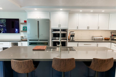 Example of a mid-sized trendy l-shaped porcelain tile, beige floor and coffered ceiling eat-in kitchen design in San Francisco with a single-bowl sink, shaker cabinets, white cabinets, quartz countertops, beige backsplash, stone tile backsplash, stainless steel appliances, an island and gray countertops