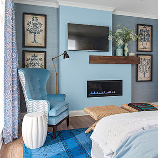 Mittelgroßes Modernes Hauptschlafzimmer mit blauer Wandfarbe, Gaskamin, hellem Holzboden, Kaminumrandung aus Metall und blauem Boden in Minneapolis