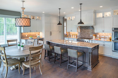 Example of a huge kitchen design in Minneapolis with white cabinets, beige backsplash, ceramic backsplash, stainless steel appliances and an island