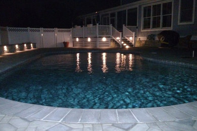 Example of a large classic backyard stone and kidney-shaped pool design in Other