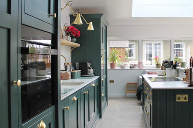 Inspiration for a mid-sized transitional single-wall limestone floor and beige floor eat-in kitchen remodel in Other with an undermount sink, shaker cabinets, green cabinets, white backsplash, black appliances, an island and white countertops
