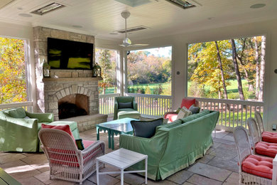 Inspiration for a large timeless stone screened-in and wood railing side porch remodel in St Louis with a roof extension
