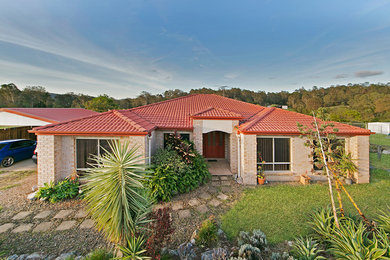 Mid-sized country one-storey brick beige exterior in Gold Coast - Tweed.