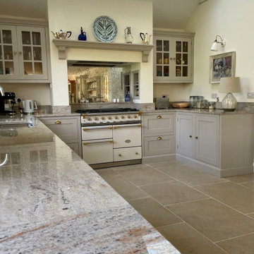 Light grey traditional handmade kitchen with glazed bar wall cabinets and mantel