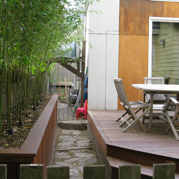 View through to storage and bamboo planter, sunken stone path, and deck
