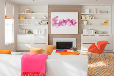 Example of a mid-sized trendy enclosed medium tone wood floor and brown floor family room design in San Francisco with white walls and a standard fireplace