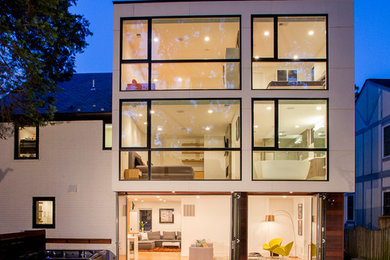 Inspiration for a large modern white split-level brick exterior home remodel in DC Metro with a shingle roof