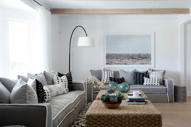 Photo of a beach style living room in New York with white walls and medium hardwood floors.