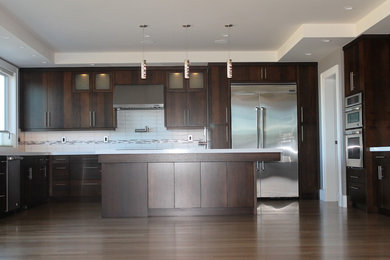 Open concept kitchen - large contemporary u-shaped light wood floor open concept kitchen idea in Vancouver with an undermount sink, flat-panel cabinets, dark wood cabinets, quartz countertops, white backsplash, glass tile backsplash, stainless steel appliances and an island
