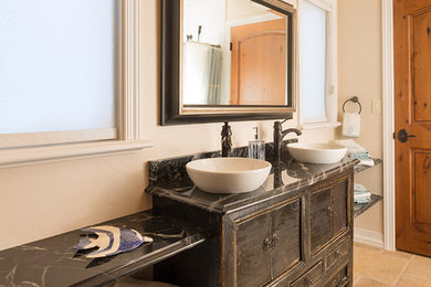 Example of a mid-sized eclectic 3/4 marble floor and yellow floor bathroom design in Other with furniture-like cabinets, dark wood cabinets, a vessel sink and marble countertops