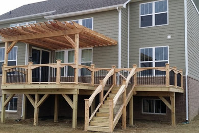 Large arts and crafts backyard deck photo in Indianapolis with a pergola
