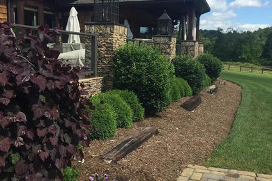 Photo of a large rustic partial sun front yard mulch driveway in Charlotte for summer.