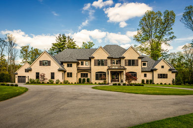 Inspiration for a huge beige three-story brick exterior home remodel in Cincinnati with a shingle roof