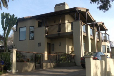 Inspiration for a large transitional beige two-story stucco gable roof remodel in San Diego