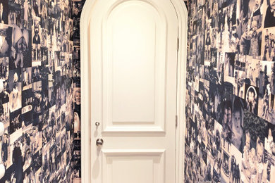 This is an example of a mid-sized traditional powder room with limestone floors and wallpaper.