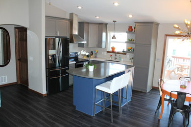 Inspiration for a mid-sized transitional l-shaped dark wood floor and black floor eat-in kitchen remodel in Other with an undermount sink, shaker cabinets, gray cabinets, solid surface countertops, stainless steel appliances and an island