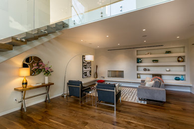 Example of a minimalist loft-style medium tone wood floor family room library design in Los Angeles with gray walls and no tv