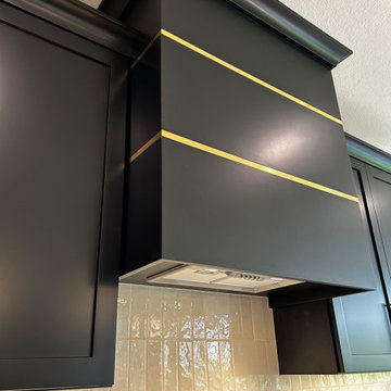 Black and Maple Wheat Kitchen with Brass Banded Hood